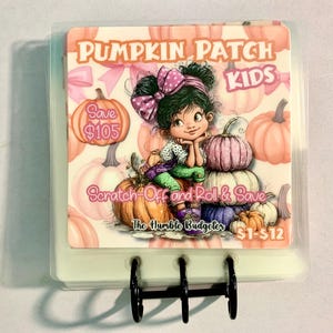 May include: A Pumpkin Patch Kids scratch-off game with a cartoon girl sitting on pumpkins. The image includes text that says "Save $105" and "Scratch Off and Roll & Save". The game is held together with black metal rings.
