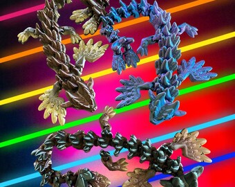 May include: Four articulated, segmented, lizard-like figures in gold, brown, blue, and green, posed against a colorful striped background.