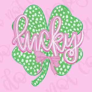 Puede incluir: Un fondo rosa presenta un trébol de cuatro hojas verde con lunares blancos. La palabra "lucky" está escrita en rosa con un contorno blanco. Un lazo rosa está en la parte inferior del trébol.