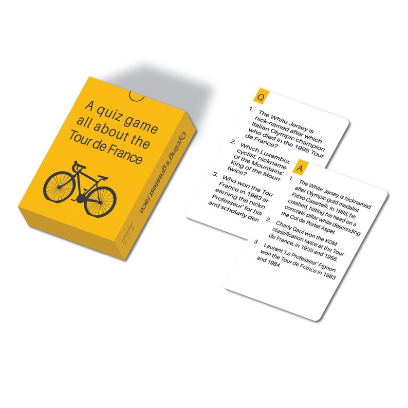 Op de afbeelding: Een gele quizspeldoos met de tekst "A quiz game all about the Tour de France" en een fietsafbeelding. Twee witte quizkaarten met vragen en antwoorden liggen naast de doos. De tekst "Cycling's greatest race" staat op de zijkant van de doos.