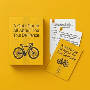 Op de afbeelding: Een gele quizgame met de tekst "A Quiz Game All About The Tour De France" en een fietsafbeelding. De kaarten bevatten quizvragen over de Tour de France. De doos en kaarten liggen op een gele ondergrond.