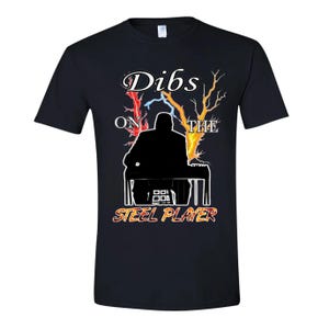 May include: Black t-shirt with a graphic featuring a silhouette of a person playing a steel guitar. The text "Dibs on the Steel Player" is displayed in a stylized font with lightning and tree branch accents.