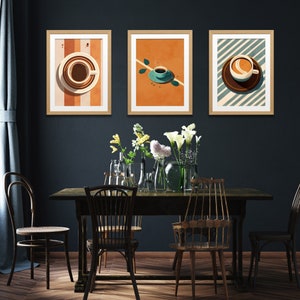 May include: Three framed prints with a minimalist design featuring coffee cups on a colorful background. The prints are hung on a dark blue wall above a wooden table with chairs.