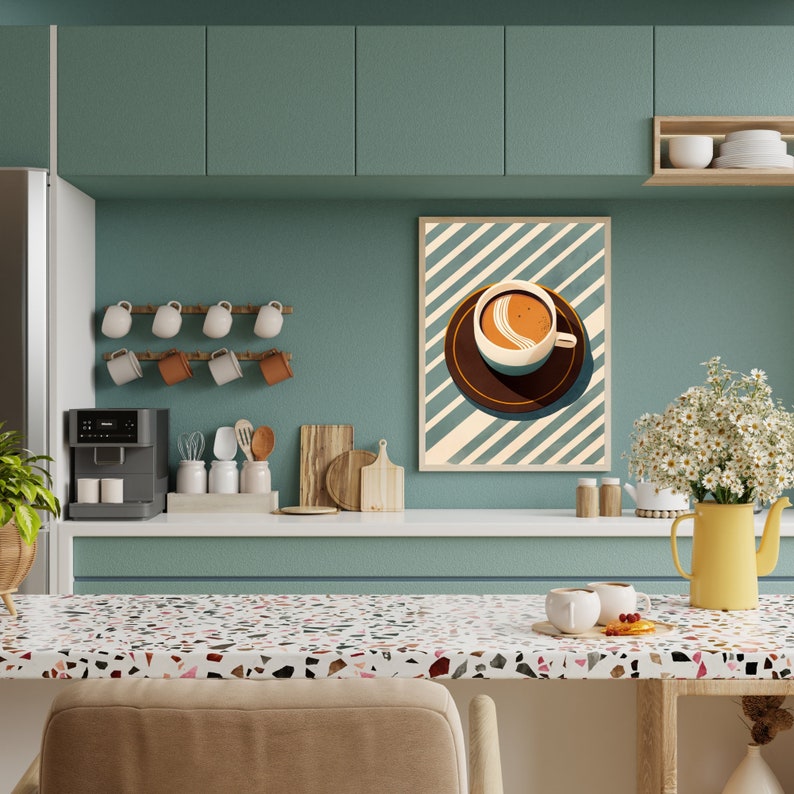 May include: A teal green kitchen with a coffee cup print hanging on the wall. The kitchen has a coffee maker, a rack of mugs, and a countertop with a terrazzo pattern.