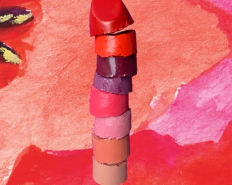 Puede incluir: Un conjunto de muestras de lápiz labial en varios tonos de rojo, rosa y morado. Las muestras de lápiz labial están dispuestas en una torre, con el tono más oscuro en la parte inferior y el tono más claro en la parte superior.