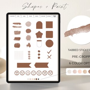 May include: A digital screen displaying a sticker book with various shapes and paint designs. The book includes a grid, circles, stars, and other shapes in brown and white. The text "Tabbed Sticker Book", "Pre-Cropped", and "6 Color Options" is displayed on the screen. The screen is on a white surface with a brown circle and a brown brush stroke in the background.