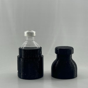 May include: A black plastic vial holder with a clear glass vial inside. The vial holder has a screw-on top and a bottom that fits snugly around the vial. The vial holder is designed to protect the vial from damage.