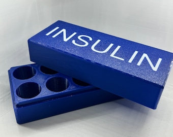 Könnte beinhalten: Ein blauer Kunststoff-Aufbewahrungskasten mit dem Wort "INSULIN" auf dem Deckel. Der Kasten hat mehrere Fächer zur Aufbewahrung von Insulin-Fläschchen.