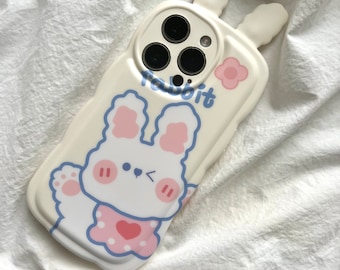 May include: A white phone case with a cartoon bunny design. The case has a raised bunny ear design and says "Rabbit" on the front.