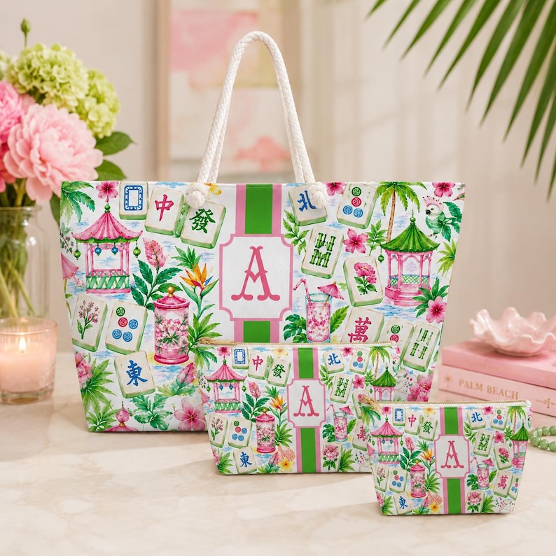 May include: A set of three matching tote bags and pouches. The bags feature a white background with a colorful print of pagodas, flowers, and Mahjong tiles. The bags have a green stripe and a pink letter "A".