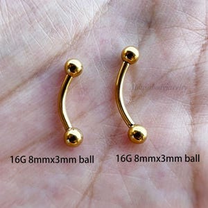 May include: Two gold 16G curved barbell body jewelry pieces with 8mm length and 3mm ball ends.