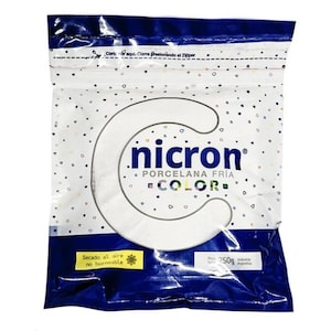 May include: A sealed plastic bag of Nicron cold porcelain clay. The bag is white with a blue border and features the Nicron logo and the words "PORCELANA FRÍA COLOR." It contains 250g of clay and has text that says "Secado al aire no horneable."