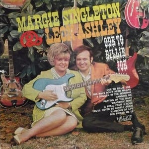 Puede incluir: Una portada de disco de vinilo vintage con Margie Singleton y Leon Ashley. El texto dice Margie Singleton & Leon Ashley, Ode to Billie Joe, y una lista de canciones. Una guitarra eléctrica color cerceta es sostenida por ambos.