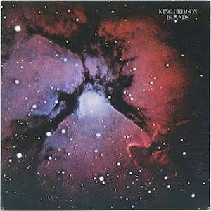 May include: Album cover art featuring a cosmic nebula with shades of red, purple, and blue. White dots represent stars scattered across the dark background. The text "KING CRIMSON ISLANDS" is in the upper right corner.