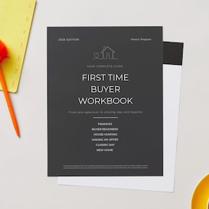 May include: A workbook titled "First Time Buyer Workbook" with the text "2026 Edition" and "Alexis Pappas". The cover is dark gray with white text and a house icon. A yellow notepad with an orange pen and a cup of coffee are also in the image.