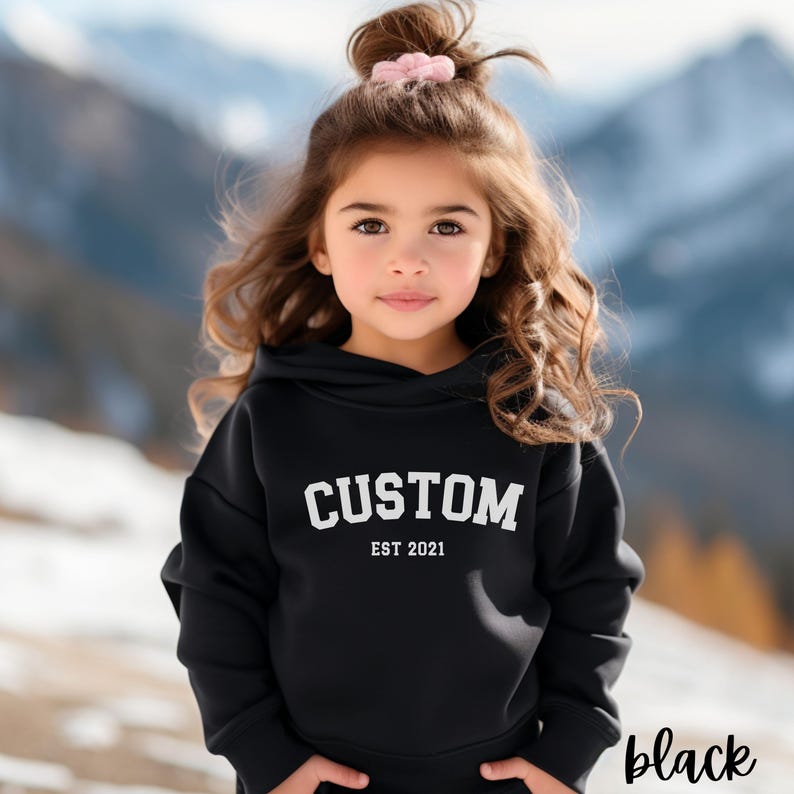 May include: Black hooded sweatshirt with the text "CUSTOM EST 2021" in white.