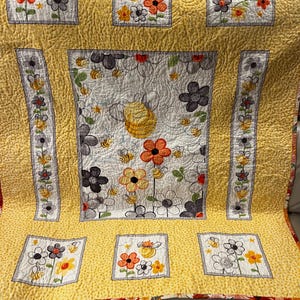 Handmade quilted baby blanket with bumblebees, flowers and yellow background