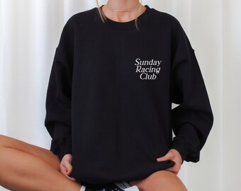 Puede incluir: Sudadera negra con el texto "Sunday Racing Club" en letras blancas.