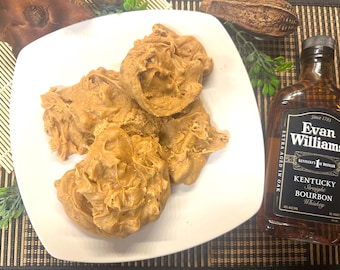 Peut inclure: Une assiette blanche avec quatre morceaux de fudge au beurre de cacahuète brun. Une bouteille d'Evan Williams Kentucky Straight Bourbon Whiskey est en arrière-plan.