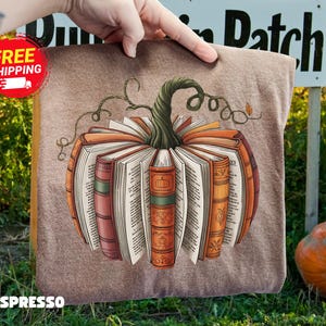 May include: A brown pillow with a pumpkin design made of books. The pumpkin is orange and brown with a green stem and vines. The word "ESPRESSO" is printed at the bottom.
