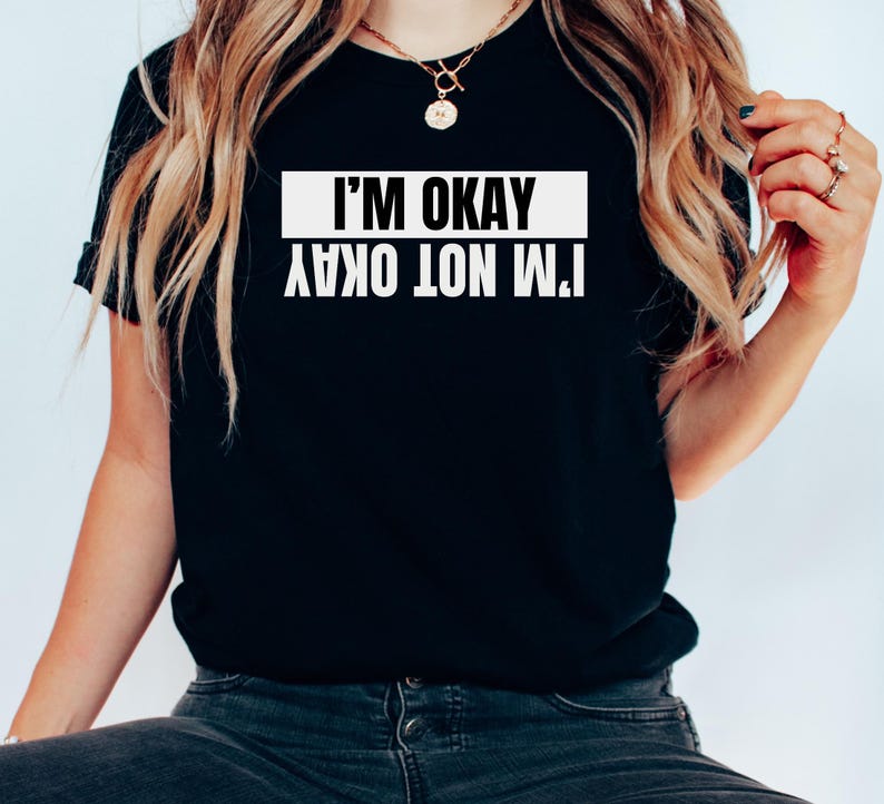 Op de afbeelding: Zwart T-shirt met witte tekst die "Het gaat niet goed met me, het gaat goed met me" zegt.
