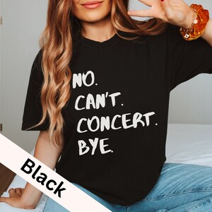 May include: Black t-shirt with white text that reads "NO. CAN'T. CONCERT. BYE."