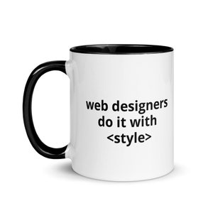 Puede incluir: Taza de cerámica blanca con borde y asa negros. La taza tiene el texto "web designers do it with <style>" impreso en ella.