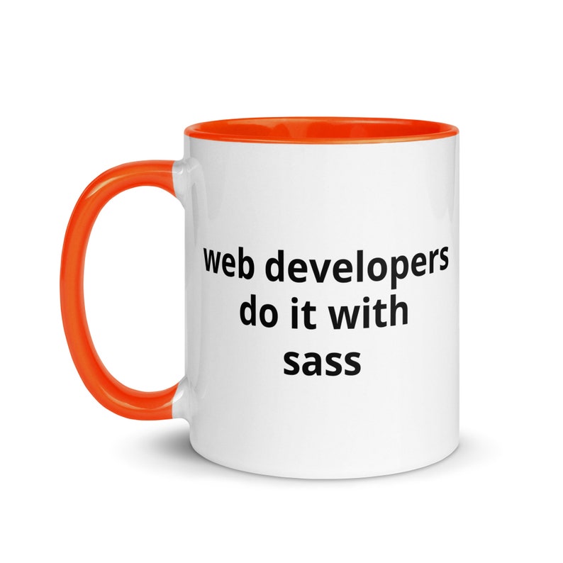 K&ouml;nnte beinhalten: Eine wei&szlig;e Kaffeetasse mit orangefarbenem Rand und Henkel. Die Tasse hat einen schwarzen Text mit der Aufschrift "web developers do it with sass".