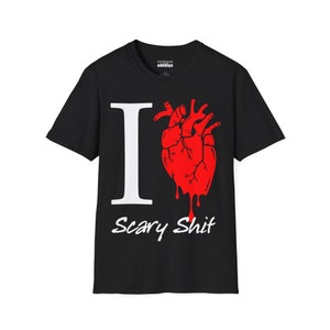 May include: Black t-shirt with a white "I" and a red dripping heart graphic. The text "Scary Shit" is printed in white below the graphic.