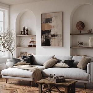 May include: A white sectional sofa with a light brown throw blanket,  three pillows with black and white geometric patterns, and a wooden coffee table with a woven basket on top. The sofa is in a living room with white walls and arched doorways.