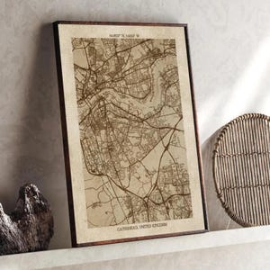 Puede incluir: Impresión enmarcada de un mapa de Gateshead, Reino Unido, en tonos sepia. El mapa presenta detalles intrincados de calles y carreteras, con el texto "GATESHEAD, UNITED KINGDOM" en la parte inferior. El marco es marrón oscuro.