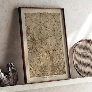 May include: Framed map print of Wheaton, United States, in sepia tones. The map features detailed street layouts and geographical features. The print is encased in a dark brown wooden frame, adding a vintage aesthetic. The text "WHEATON, UNITED STATES" is visible at the bottom.