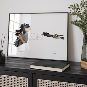 Peut inclure: Une carte aquarelle noire et dorée de l'Irlande et de la Jamaïque reliées par une ligne avec deux cœurs. Les mots "Irlande" et "Jamaïque" sont écrits sous les cartes.