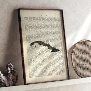 May include: A framed vintage map of Cuba, presented in a dark brown wooden frame. The map is monochrome, with the word "CUBA" at the top. The map is surrounded by text.