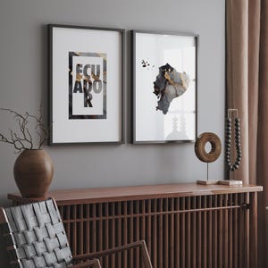 May include: Two framed prints with a white background. The print on the left features the word "ECUADOR" in black and gold lettering. The print on the right features a black and gold outline of Ecuador.