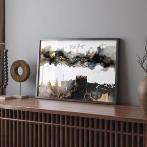 Può includere: Stampa artistica incorniciata con lo skyline di High Point, Carolina del Nord, in nero e oro. L'opera d'arte ha un effetto acquerello con lavaggi di inchiostro astratti neri, dorati e grigi sopra la silhouette della città. Le parole "High Point" sono scritte in corsivo.