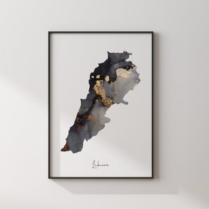 May include: A black and gold abstract art print of the country of Lebanon. The print is framed in a black frame and has the word "Lebanon" written in cursive at the bottom.