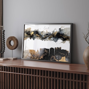 May include: Black and gold abstract art print featuring the city skyline of Everett, Washington. The print is framed in a black frame and is hanging on a wall.