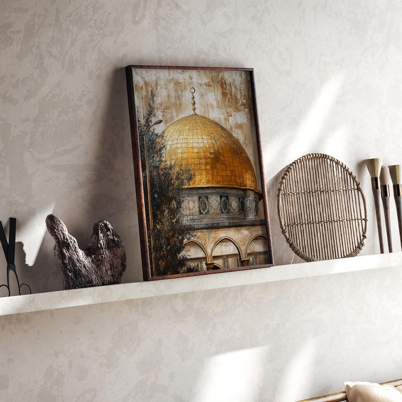 May include: A framed painting of a golden dome building with intricate details. The building is set against a background of trees and a blue sky. The painting is in a brown frame and is hanging on a wall.
