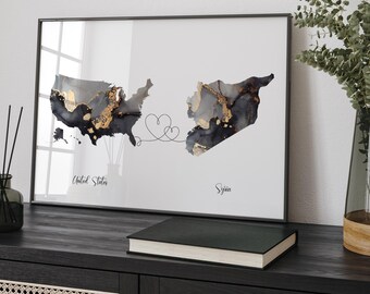 May include: A framed print with a black and gray watercolor map of the United States and Syria connected by a line with two hearts. The text "United States" and "Syria" is printed below each map.