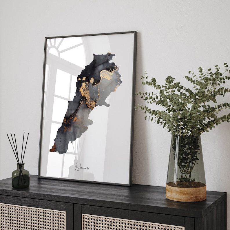 May include: A black and gold abstract art print of the country of Lebanon. The print is framed in a black frame and is hanging on a wall. The print is in a modern style and would look great in any home.