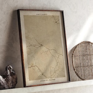 Può includere: Stampa di mappa in stile vintage incorniciata di Angeles City, Filippine, con coordinate in alto. La mappa presenta una rete di linee su sfondo beige, racchiusa in una cornice di legno marrone scuro. Il testo "ANGELES CITY, PHILIPPINES" è in basso.
