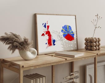 May include: A framed watercolor print featuring the map of Great Britain and Reunion Island, with the flags of each country incorporated into the design. The artwork is displayed on a wooden shelf with decorative items.