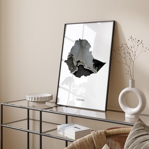 Może przedstawiać: Minimalistyczny plakat w czerni i bieli przedstawiający mapę Etiopii z napisem "Etiopia" wydrukowanym pod mapą.