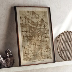 May include: A framed map of Hammond, United States, in sepia tones. The map is detailed with streets and landmarks, and the frame is a dark brown. Coordinates are at the top, and the city name is at the bottom.