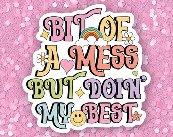 May include: A colorful sticker with the text "Bit of a mess but doin' my best" with a rainbow, hearts, stars, and flowers.
