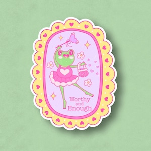 May include: A pink and yellow sticker with a cartoon frog wearing a pink tutu and holding a pink purse. The frog is surrounded by hearts and flowers. The text "Worthy and Enough" is written below the frog.