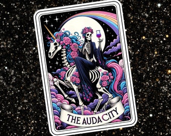 May include: A tarot card with a black and white skeleton riding a unicorn. The card has a rainbow background and the text "THE AUDACITY" at the bottom.