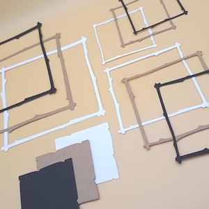May include: An assortment of square frames in black, white, and tan, with a unique branch-like design. Several frames are arranged on a light tan surface, with a few individual squares in matching colors. The frames are likely for crafts or art projects.
