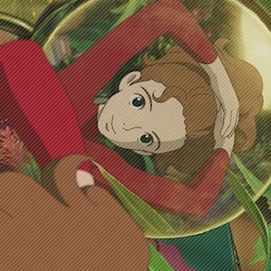 May include: A young girl with brown hair lies on her back in a red shirt, surrounded by green leaves and a large, clear, round object.